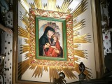 Wizerunek Maryi z dzieciątkiem trzymanym na lewym ramieniu, w prawej dłoni trzymającej owoc jabłoni lub brzoskwini 